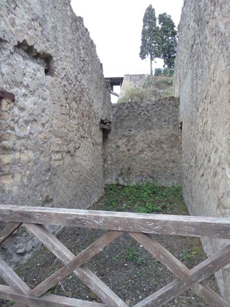 Ins. Orientalis II.12, Herculaneum. September 2015.
Looking east across hallway towards one doorway in the north wall (possibly a small storeroom) on left, and one in the south wall linked to Ins. Or. II.11, on right.